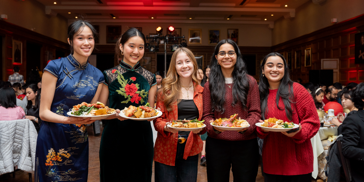 Two Western students in residence dining hall during the Lunar New Year celebration enjoying cultural foods.